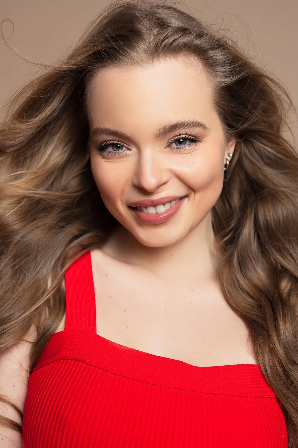 Smiling close-up of Nina Schwarz in a red top with windswept hair