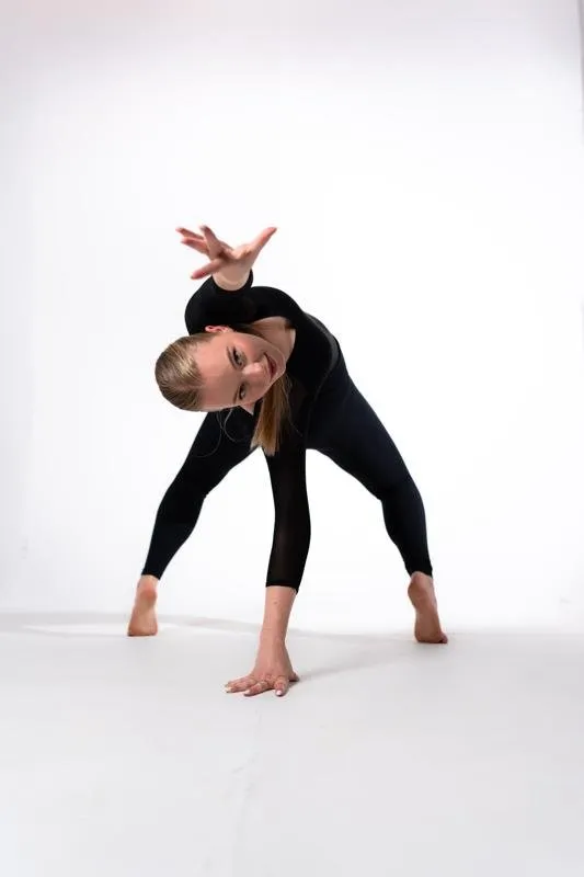 Nina Schwarz in a low dance pose, bending forward with crossed arms