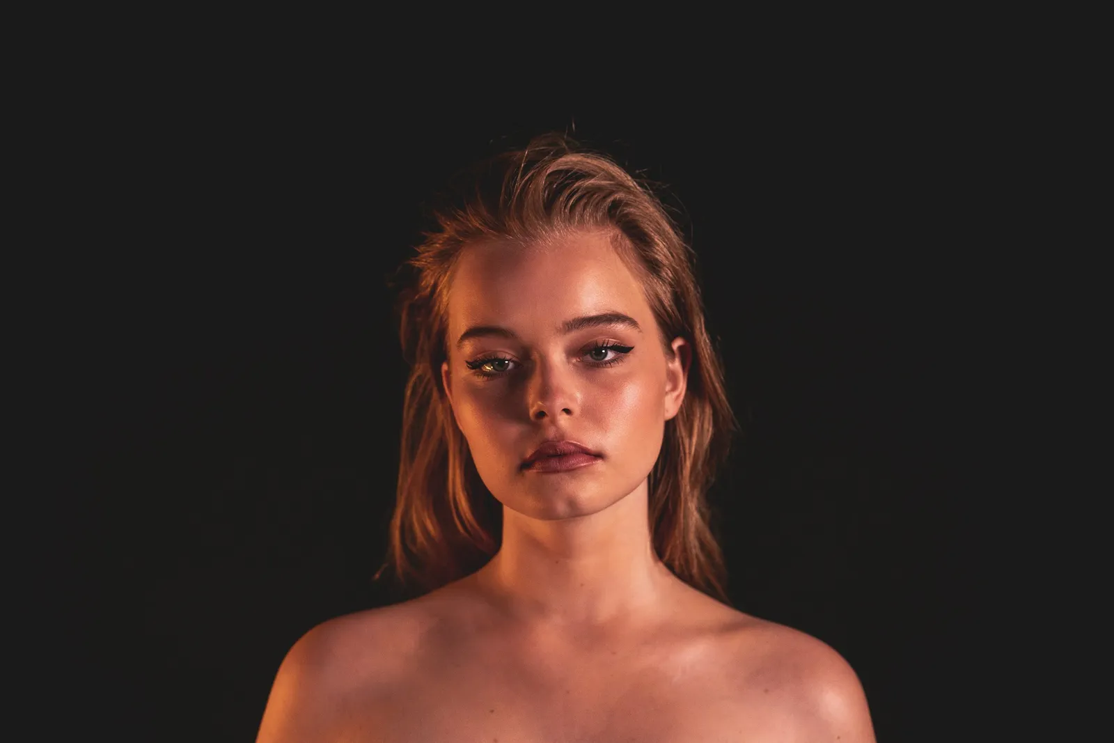 Portrait of Nina Schwarz in warm light against a black background